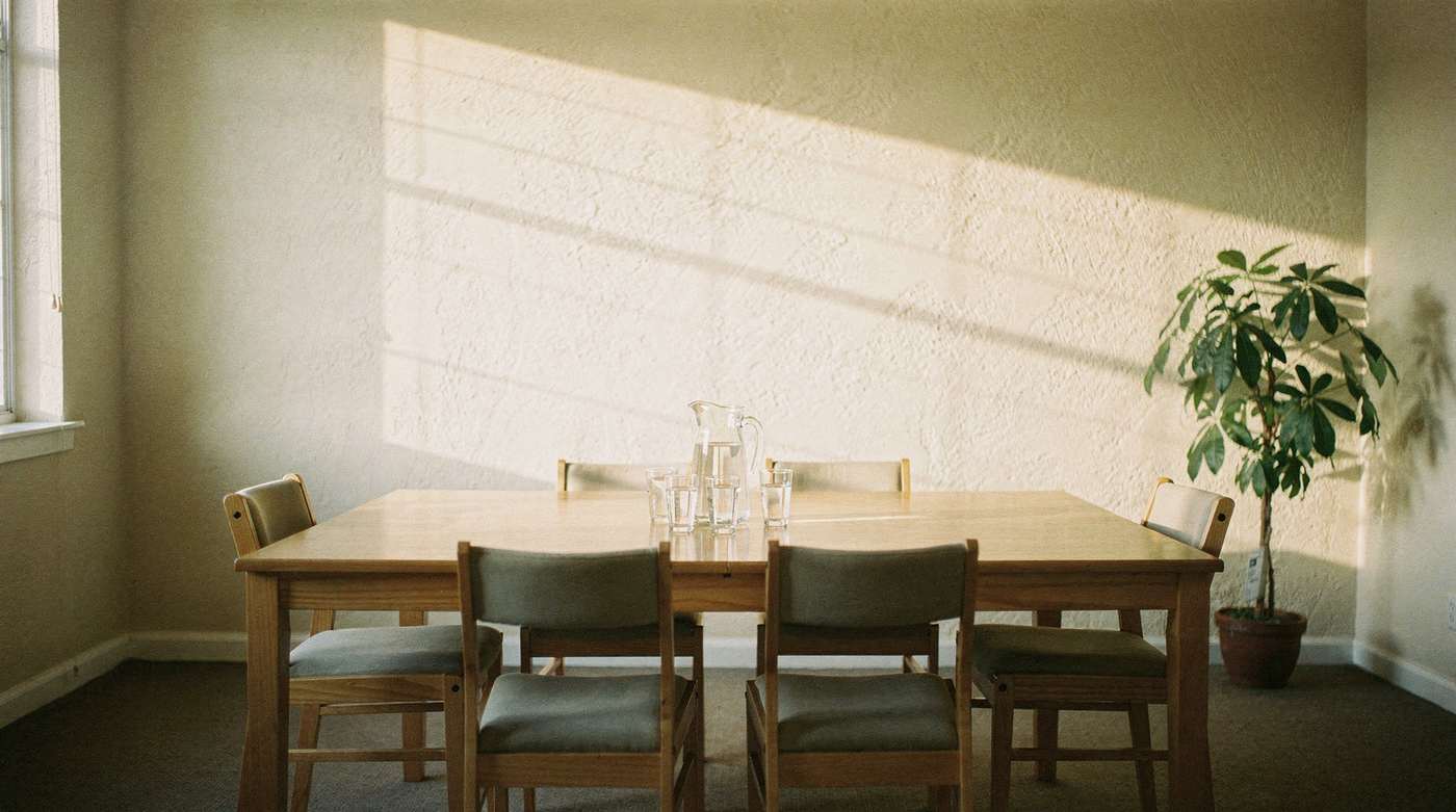A clubhouse meeting room set up with a table, chairs and water before a board meeting